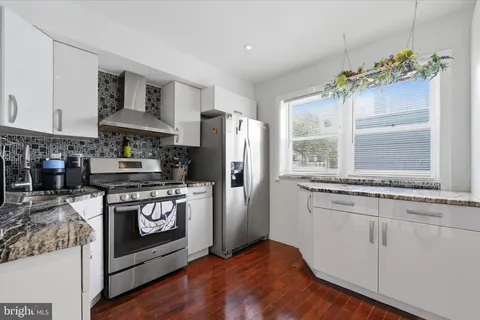 a kitchen with stainless steel appliances granite countertop a stove a refrigerator and a stove
