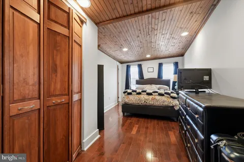 a room with a bed and a flat tv screen
