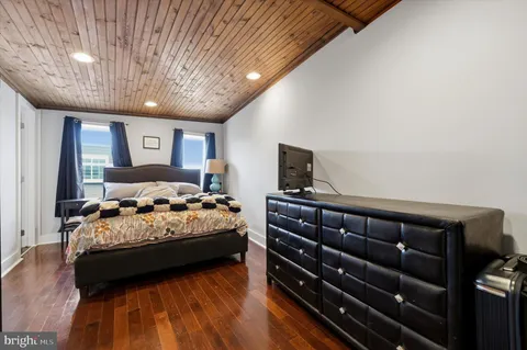 a bedroom with bed and wooden floor