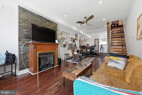 a living room with furniture a flat screen tv and a fireplace