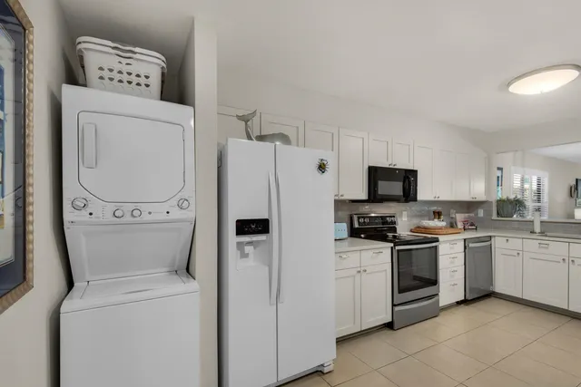a kitchen with a sink a stove top oven and white stainless steel appliances