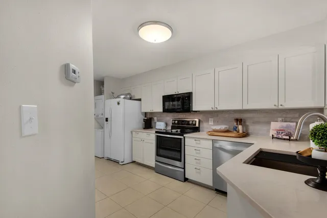 a kitchen with white cabinets and stainless steel appliances