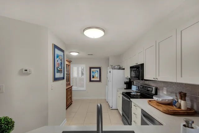 a kitchen with stainless steel appliances granite countertop a refrigerator a sink a stove top oven a counter space and cabinets