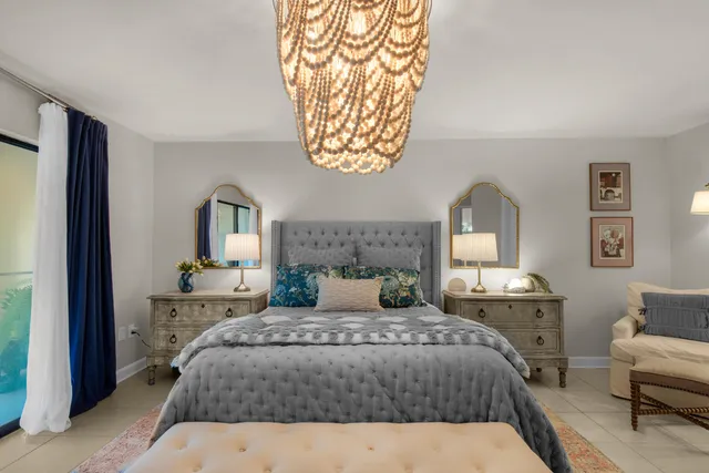 a bedroom with a large bed and a chandelier