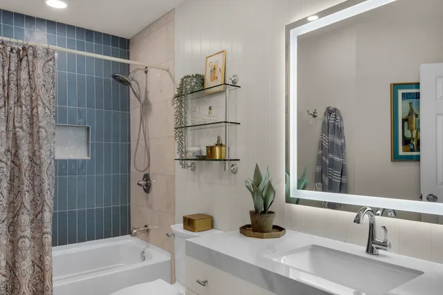a bathroom with a tub sink and mirror