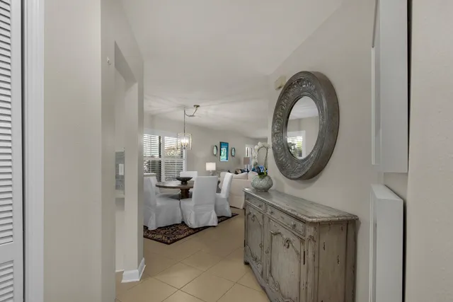 a living room with furniture a mirror and white walls
