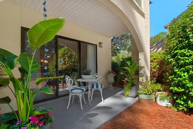 a view of a porch with chairs and potted plants