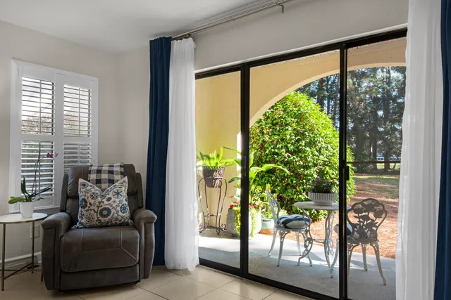 a living room with furniture and a floor to ceiling window