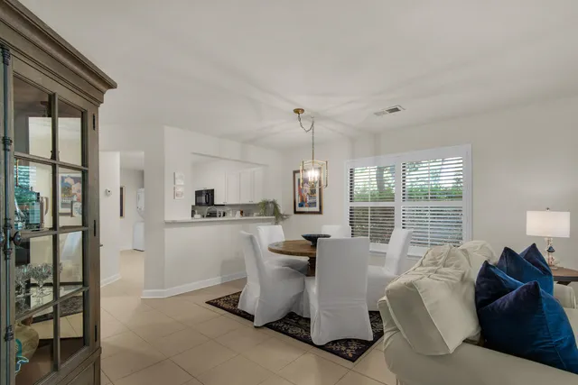 a living room with furniture a large window and wooden floor