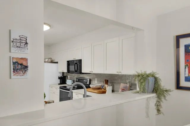 a kitchen with stainless steel appliances a stove a sink a refrigerator a counter top space and cabinets