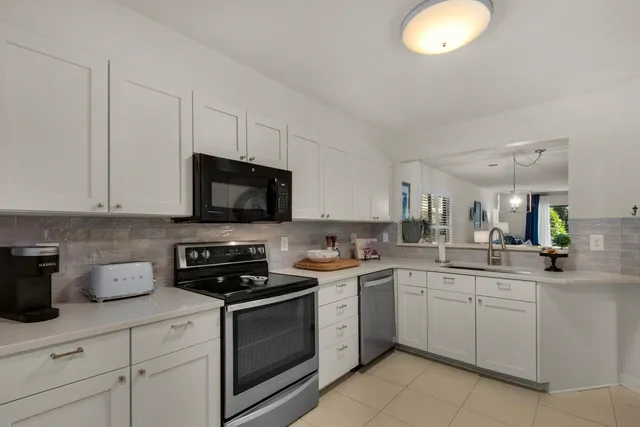 a kitchen with white cabinets and white appliances