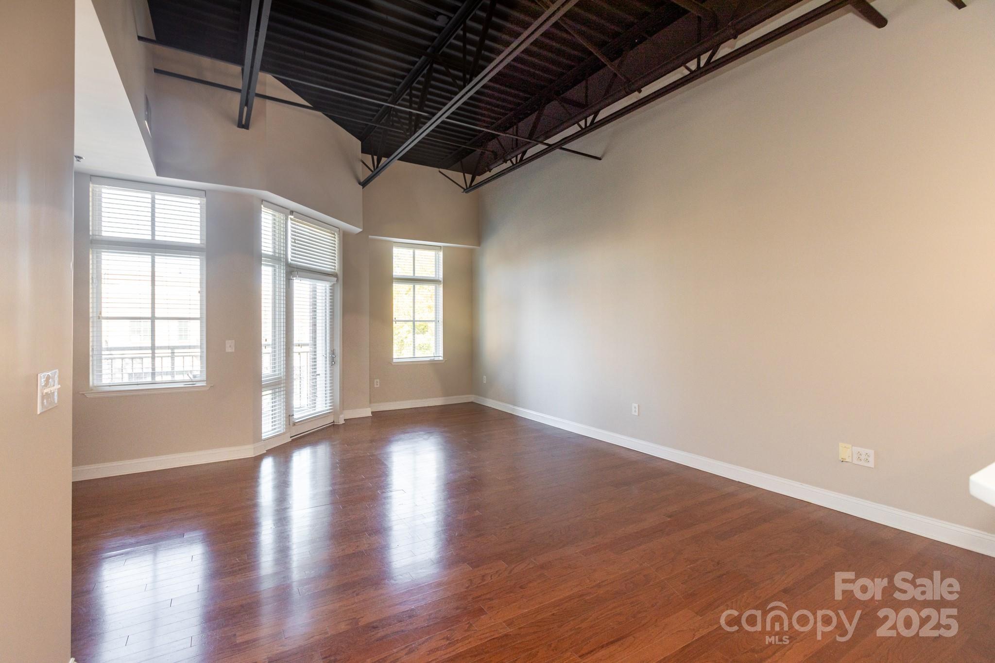 3920 Sharon Road Charlotte, NC 28211 - Photo 5 of 38 a view of an empty room with wooden floor and a window