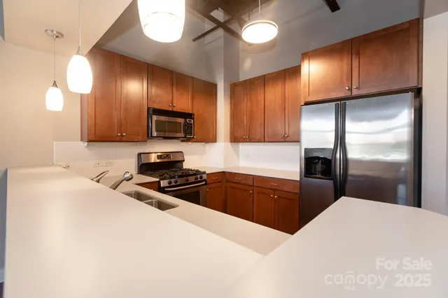a kitchen with granite countertop stainless steel appliances and wooden cabinets