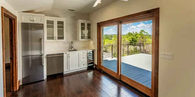 a kitchen with a refrigerator and wooden floor