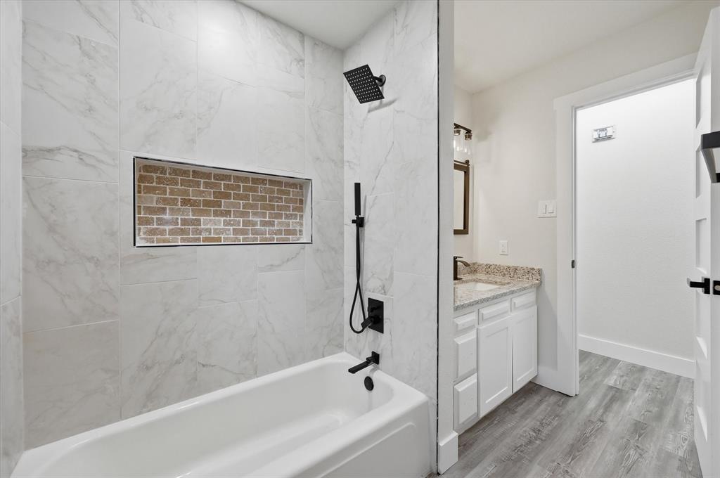 2804 Bent Tree Lane Arlington, TX 76016 - Photo 23 of 32 a bathroom with a tub shower and sink