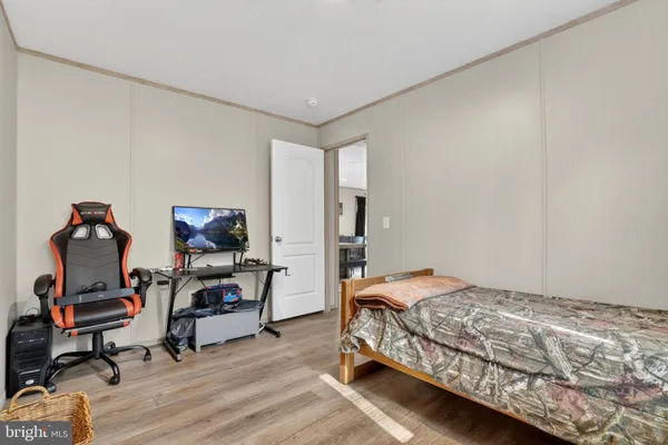 a bedroom with a bed and wooden floor