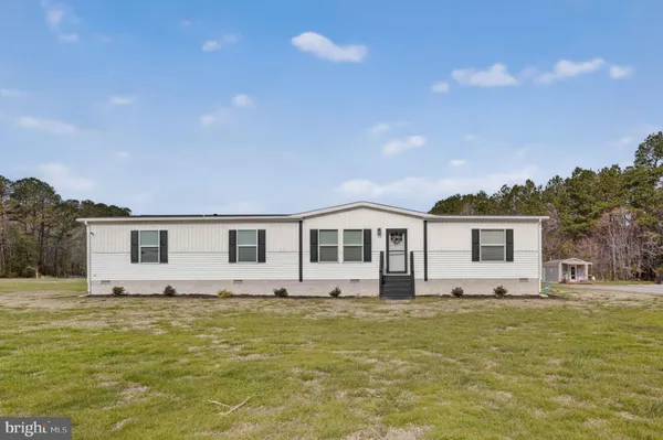 a front view of house with yard and trees around