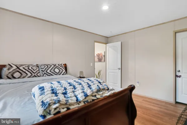 a bedroom with a bed and wooden floor