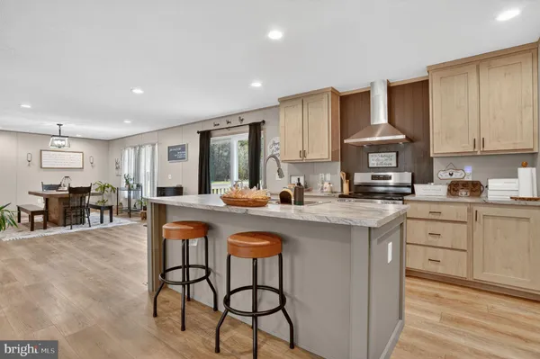 a kitchen with stainless steel appliances granite countertop a table chairs sink refrigerator and cabinets