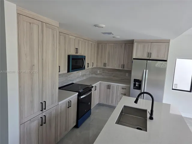 a kitchen with granite countertop a stove a sink dishwasher and a refrigerator