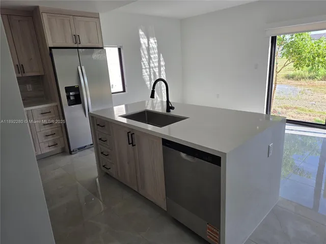 a kitchen with stainless steel appliances a refrigerator and a sink