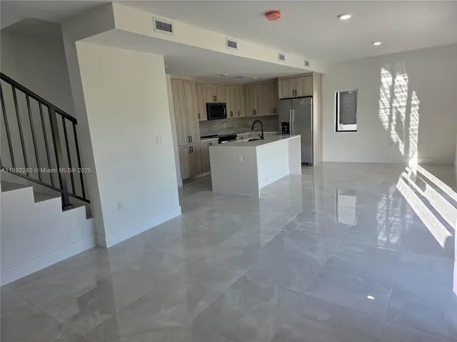 a view of a kitchen with microwave and refrigerator