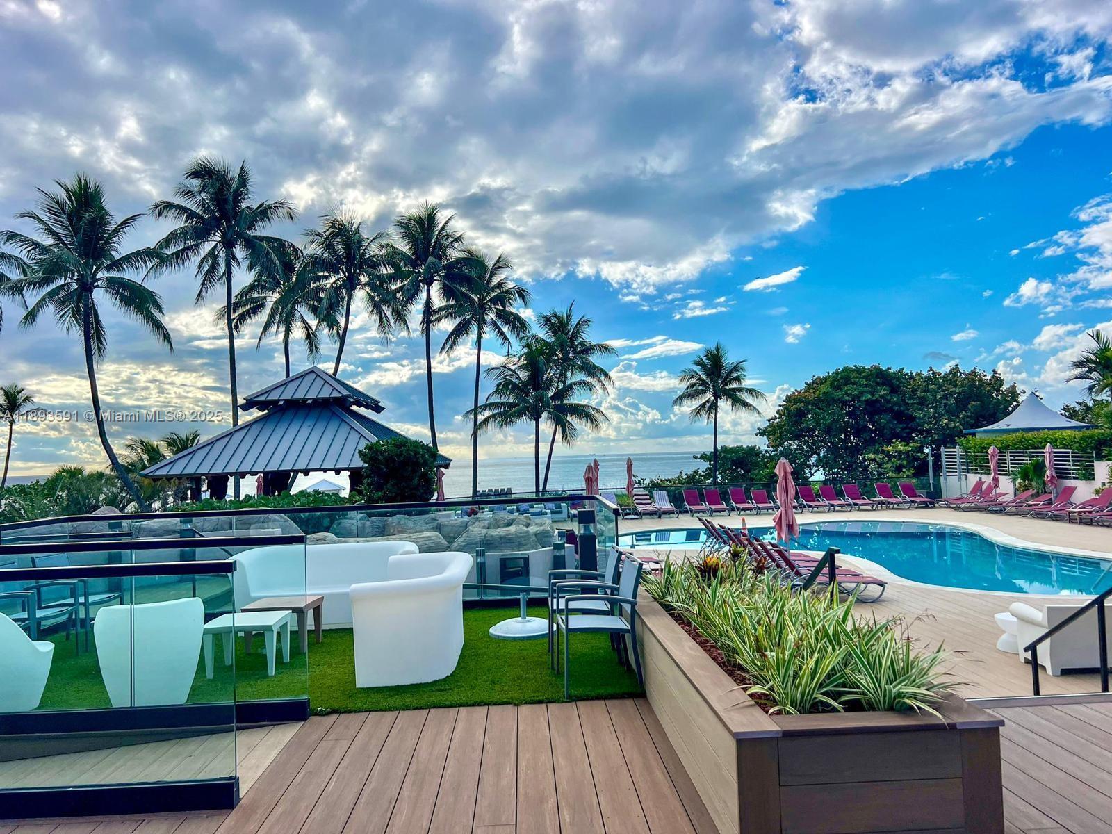 5225 Collins Avenue, Unit 517 Miami Beach, FL 33140 - Photo 1 of 20 a view of a swimming pool with a patio and a garden