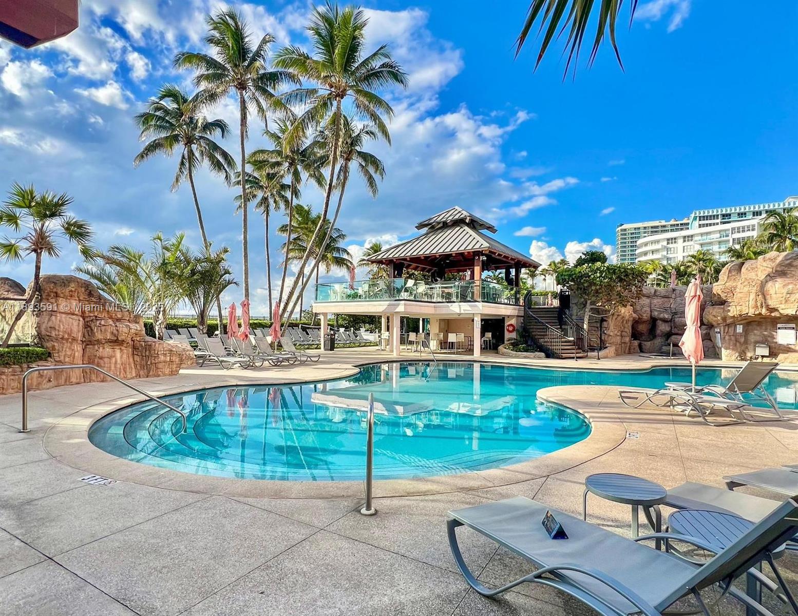 5225 Collins Avenue, Unit 517 Miami Beach, FL 33140 - Photo 2 of 20 a swimming pool with outdoor seating yard and barbeque oven