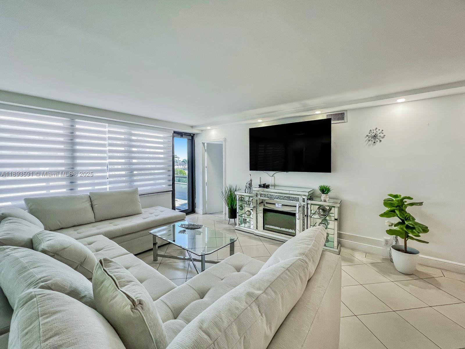 5225 Collins Avenue, Unit 517 Miami Beach, FL 33140 - Photo 3 of 20 a living room with furniture and a flat screen tv