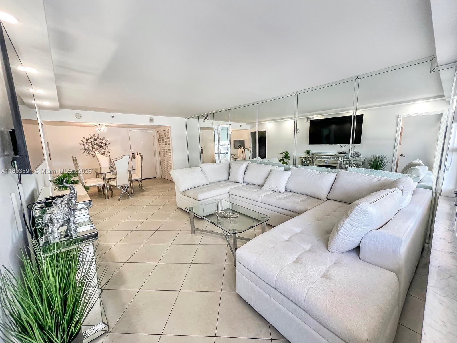 5225 Collins Avenue, Unit 517 Miami Beach, FL 33140 - Photo 4 of 20 a living room with furniture a flat screen tv and a table