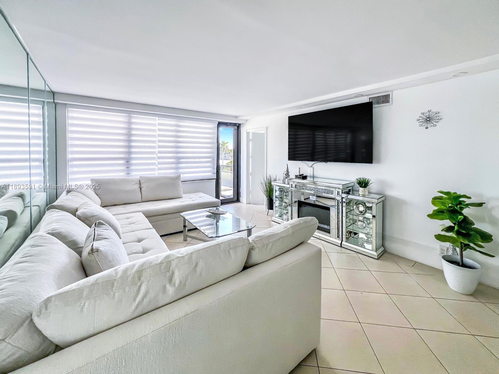 5225 Collins Avenue, Unit 517 Miami Beach, FL 33140 - Photo 7 of 20 a living room with furniture and a flat screen tv