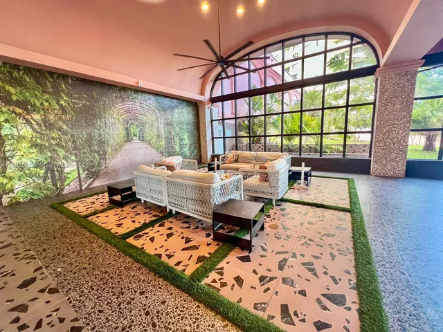 a living room with furniture and floor to ceiling windows