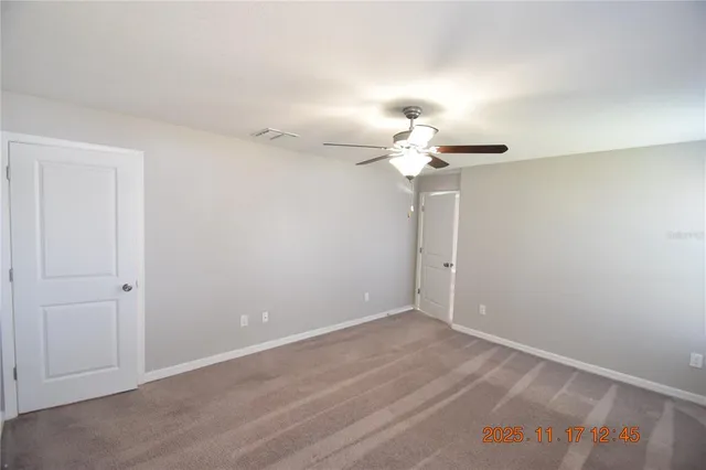 an empty room with a chandelier fan