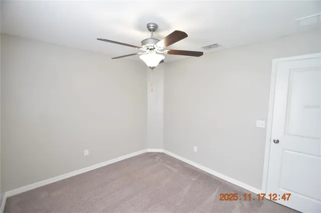 an empty room with a window and a fan