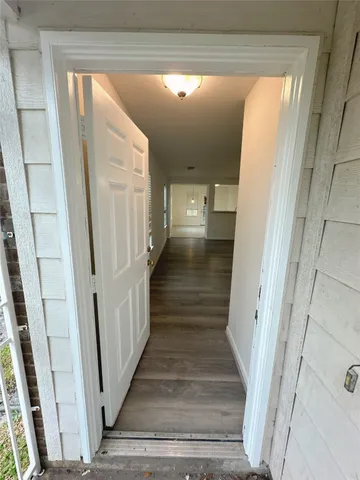 a view of a hallway with wooden floor and staircase