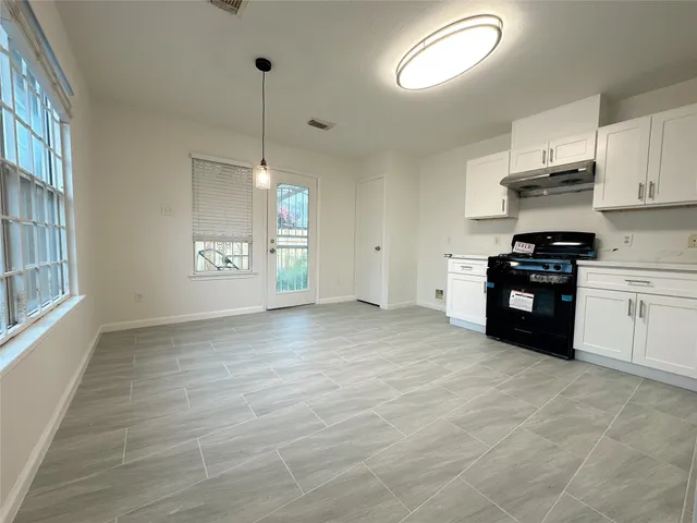 a kitchen with granite countertop a stove a sink and a refrigerator