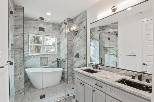 a bathroom with a double vanity sink a mirror and a bathtub