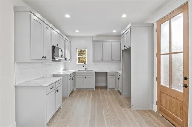 a kitchen with a sink refrigerator and cabinets