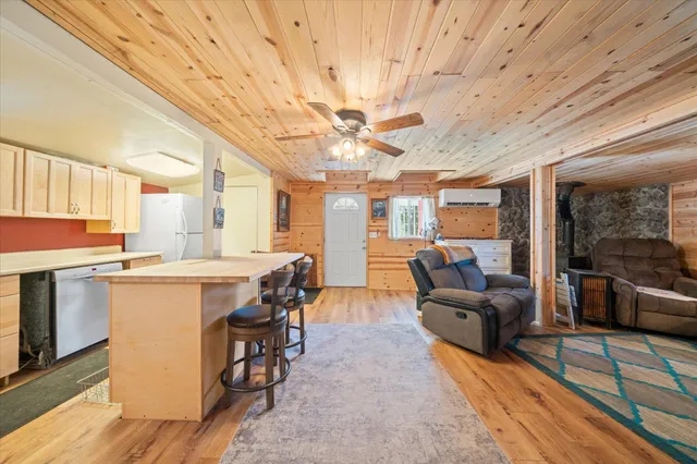 a large living room with stainless steel appliances granite countertop couches a chandelier with kitchen view