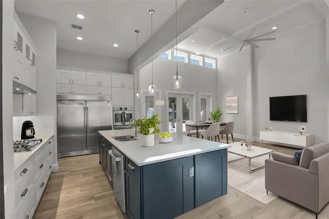 a large kitchen with a counter top space a sink stainless steel appliances and cabinets