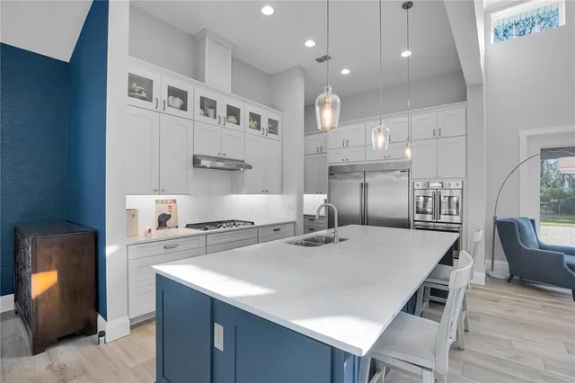 a kitchen with kitchen island a stove a table and chairs