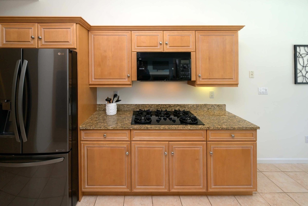 173 Nobscot Road, Unit 173 Sudbury, MA 01776 - Photo 12 of 37 a kitchen with granite countertop a refrigerator stove and microwave
