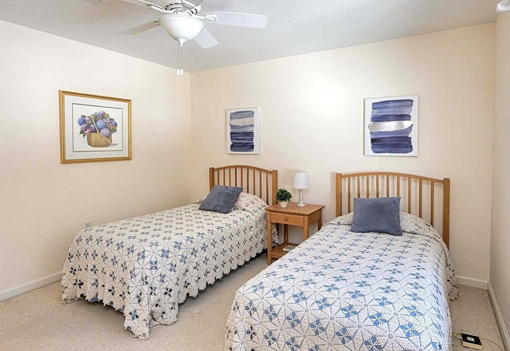 173 Nobscot Road, Unit 173 Sudbury, MA 01776 - Photo 24 of 37 a bedroom with two beds and a lamp