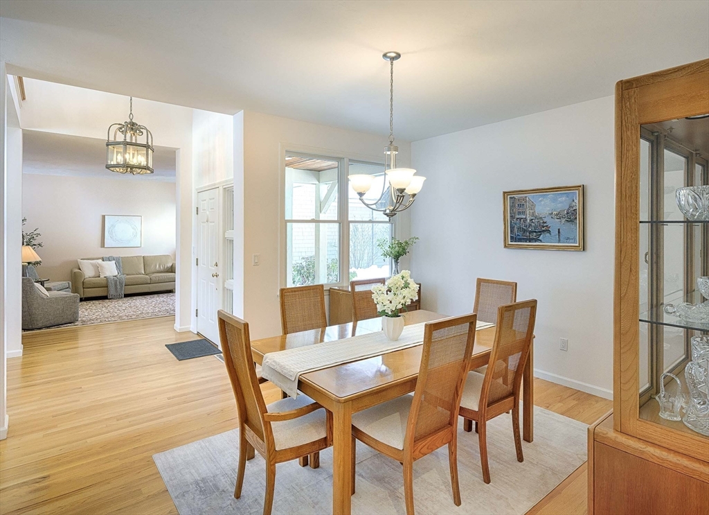 173 Nobscot Road, Unit 173 Sudbury, MA 01776 - Photo 5 of 37 a dining room with furniture a chandelier and wooden floor