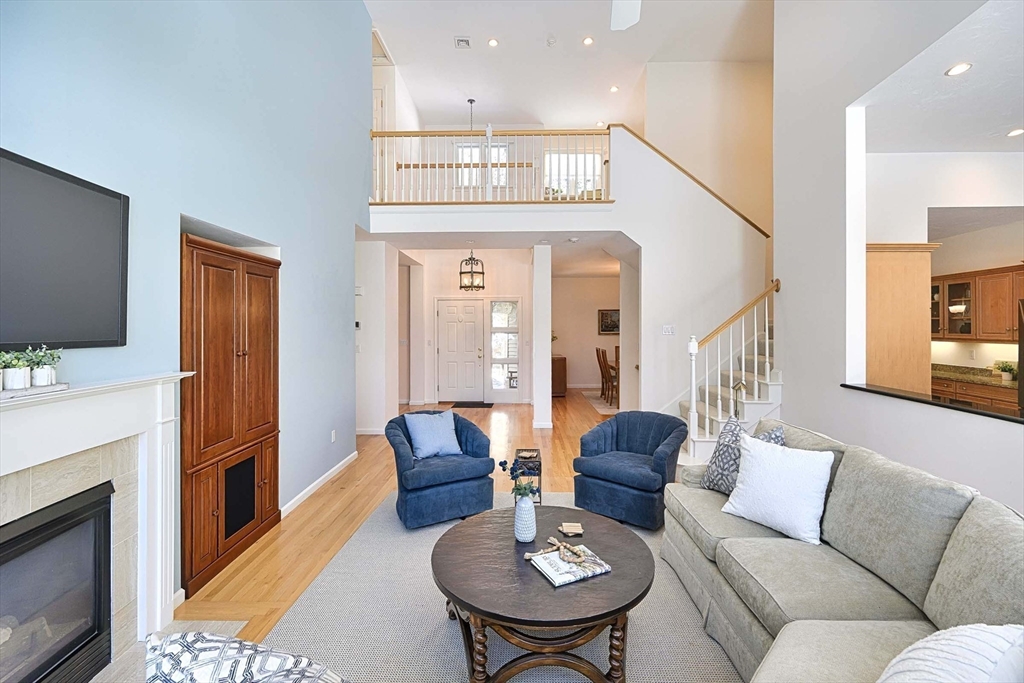 173 Nobscot Road, Unit 173 Sudbury, MA 01776 - Photo 6 of 37 a living room with furniture a fireplace and a flat screen tv
