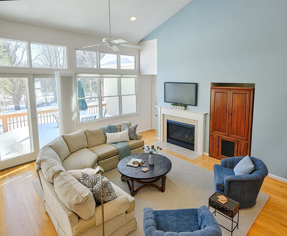 173 Nobscot Road, Unit 173 Sudbury, MA 01776 - Photo 7 of 37 a living room with furniture a fireplace and a large window