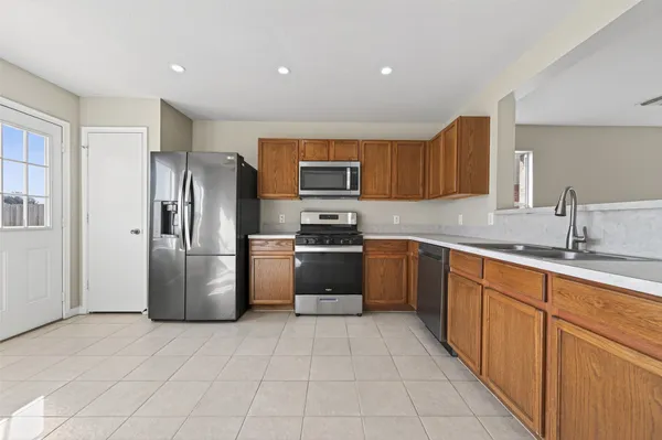 a kitchen with stainless steel appliances granite countertop a refrigerator and a stove top oven