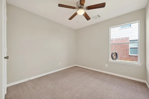 an empty room with chandelier fan