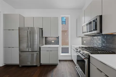 a kitchen with stainless steel appliances a refrigerator sink and microwave