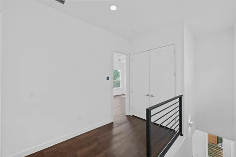 a view of a hallway with wooden floor and entryway
